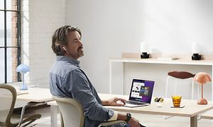 Man sitter vid skrivbordet med sin MacBook