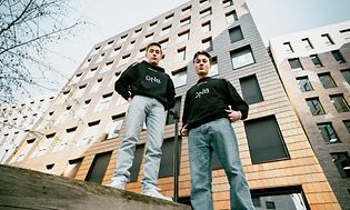 Endretta och Nyhrox som står framför en hög byggnad i Oslo