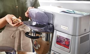 En kvinna ska lägga i svamp i en Kenwood Cooking Chef XL köksmaskin bakskål 