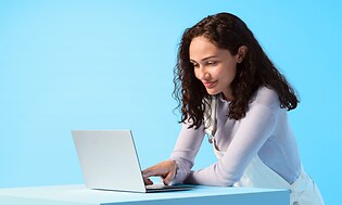 Kvinna som står och arbetar på en dator
