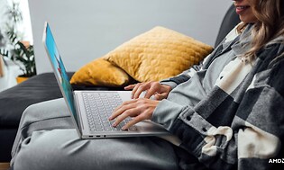 Kvinna på en soffa med bärbar dator i knäet