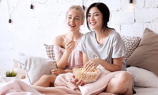 Calman - Två kvinnor som äter popcorn