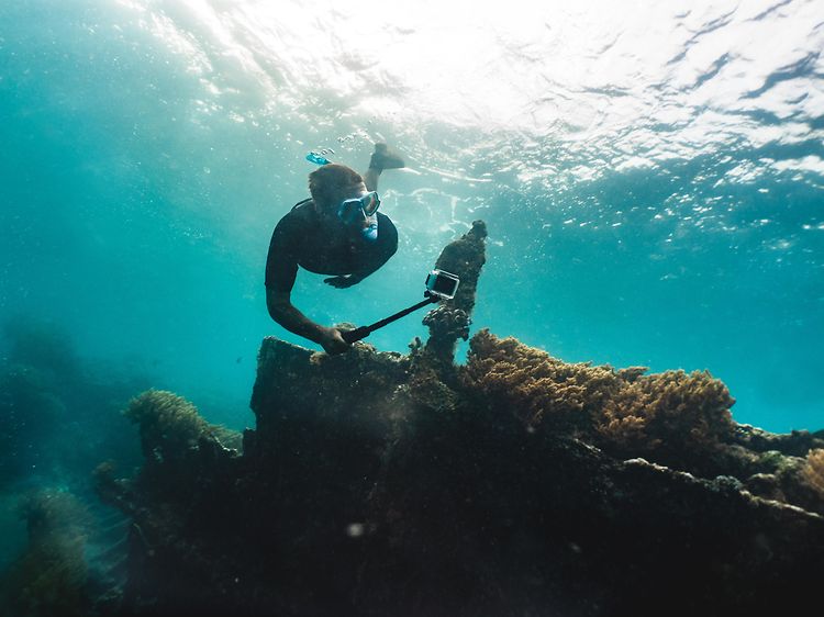 Man dyker på korallrev och filmar med GoPro