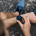 En man som har på sig en svart smartwatch med digitala siffror som lyser