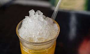 Glas med lemonad med krossad is som toppar sig uppepå