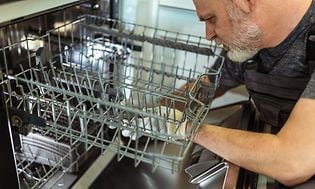 Man is repairing a dishwasher