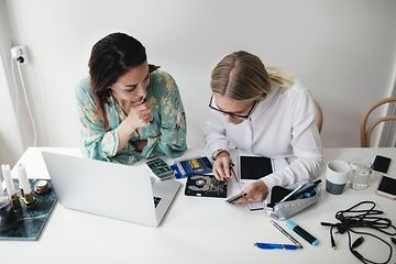 Two women repairing electronics