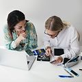 Two women repairing electronics