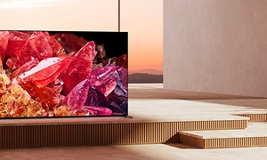 Sony-X95K TV-skärm som visar fina ädelstenar med ett stort fönster bakom där man kan se vatten och fjäll