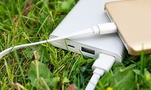 Powerbank laddar en smartphone i gräset