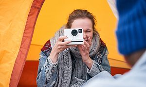 En kvinna tar en bild med en polaroidkamera