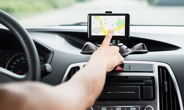 En person som kör bil och använder en GPS