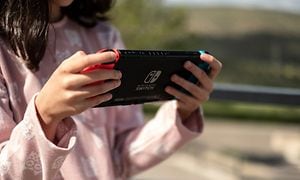 A little girl is holding a Nintendo Switch 