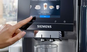 Finger som trycker på displayen på Siemens EQ700 espressomaskin
