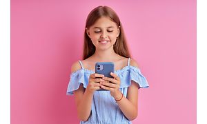 Liten flicka som håller en telefon med ett silikonskydd
