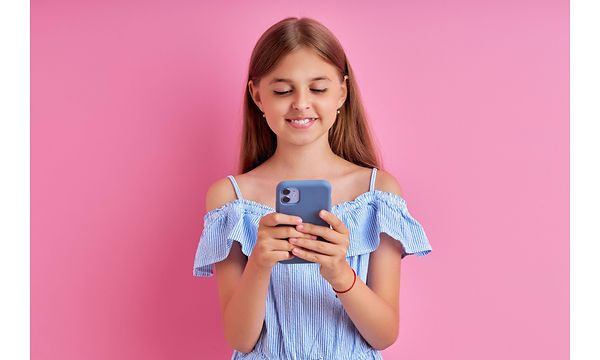Liten flicka som håller en telefon med ett silikonskydd