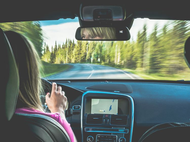 Kvinna som kör med GPS-navigering