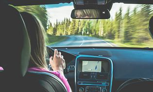 Kvinna som kör med GPS-navigering