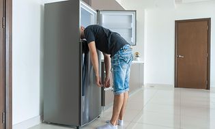 SDA-Cooling-Man putting head in a fridge freezer-min