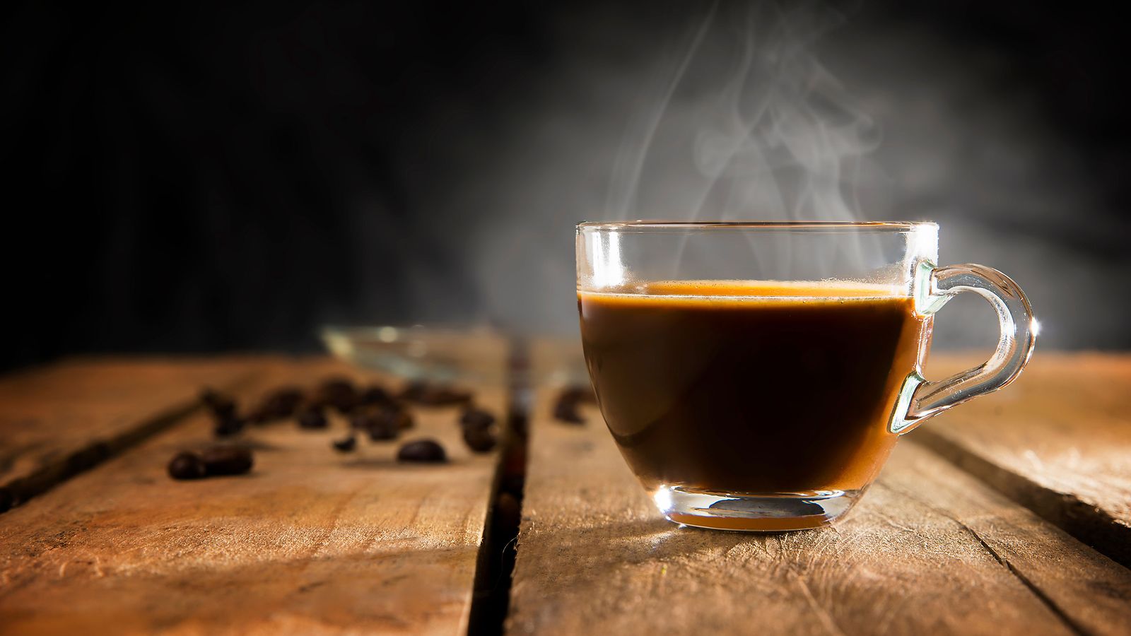 Fråga oss om kaffe: En rykande kopp kaffe på ett träbord.