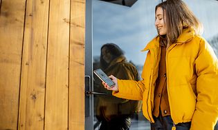 Kvinna som låser ett smart dörrlås