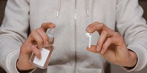 Brown goods -Earbuds -Man holding cleaning spray and earbuds-min