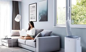 SDA-Cooling - Woman working in the couch with a portable airconidition in the room