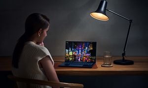 ZenBook 14 OLED - Kvinna använder datorn på ett bord