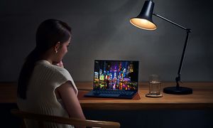 ZenBook 14 OLED - Kvinna använder datorn på ett bord