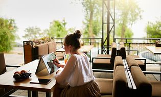 Computing-Woman sitting outside working with a tablet