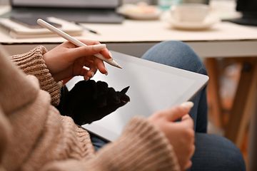 Computing-Woman holding a white pen over a tablet