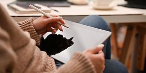Computing-Woman holding a white pen over a tablet