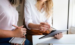 Computing-Two business women comparing notes with tablets