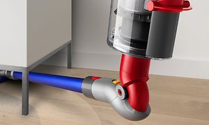 Närbild på Dyson V10 dammsugare, med adapter, som dammsuger under möbler 