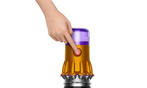 En hand som trycker på strömknappen på Dyson V12 Slim 