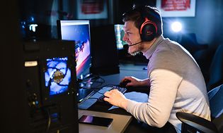 Man spelar på en stationär gamingdator
