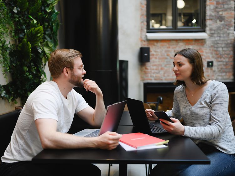 Man och kvinna jobbar på laptops