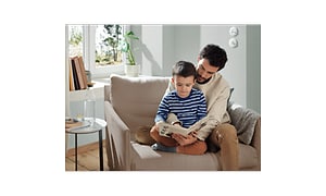 Man and child sitting in a chair reading