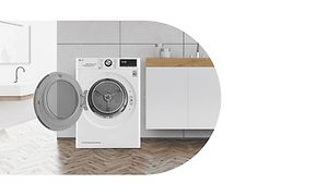 White LG dryer standing in a bathroom with its door open