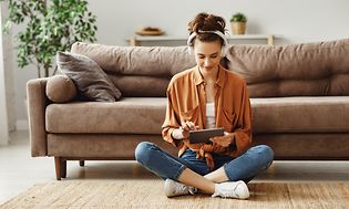 Woman sitting on floor using a tablet