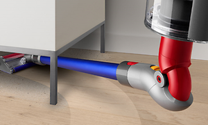 Demonstration av flexibiliteten hos en Dyson v11 total clean som dammsuger under en byrå