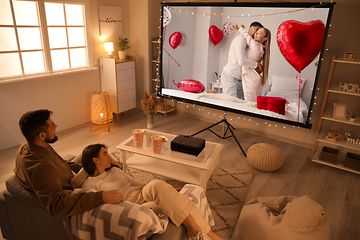 TV - Par som sitter framför projektorduk