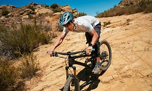 Man på en mountainbike med en Galaxy Watch5 Pro på armen