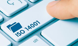 Närbild av ett finger som trycker på en tangent på ett tangentbord för dator med texten ISO 14001