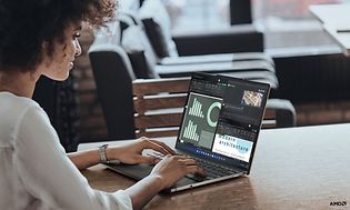 Glad kvinna använder Lenovo bärbar dator för att titta på olika statistiska staplar