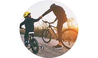 CS - Insurance - Man and boy holding hands and riding bicycles