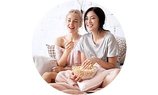CS -Support-Mother and daughter eating popcorn in a sofa