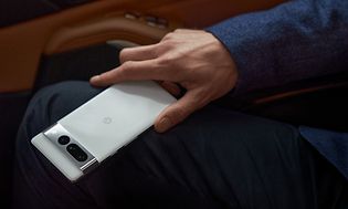 Vit Pixel-telefon i en persons knä