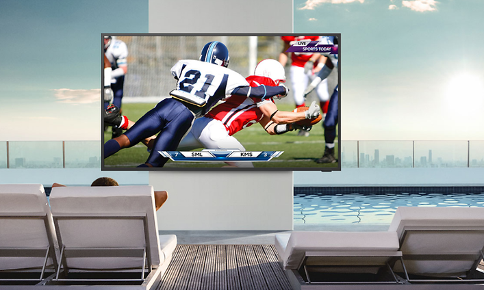 Samsung The Terrace som visar en football-match vid en poolkant med solstolar med en storstad i bakgrunden 