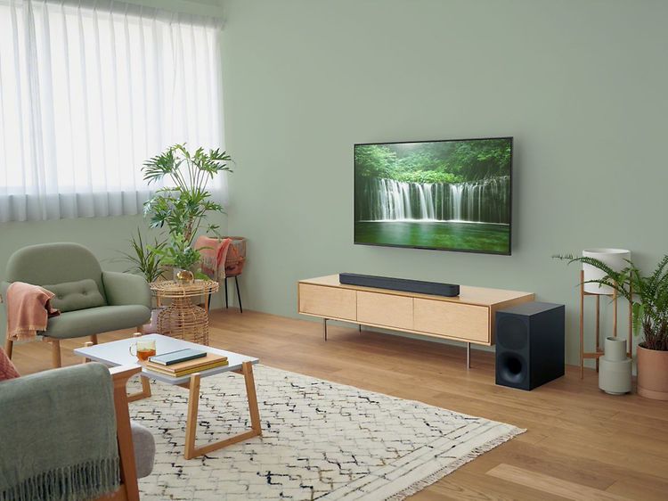 Sony Soundbar på en TV-bänk under en TV som visar ett vattenfall